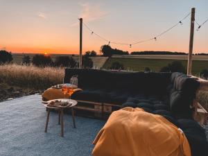 a couch and a table with a sunset in the background at Pauls Neschd Apartment in Dormettingen