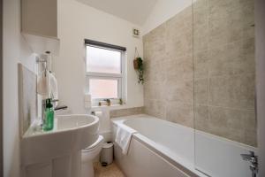 レッドカーにあるThe Alfred Suiteの浴槽と洗面台のある白いバスルーム +56枚の写真