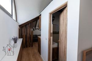 a hallway with a door leading to a bathroom at Casuta de pe dealul Cojocului in Runcu +30 photos