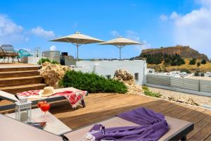 a rooftop deck with a view of the mountains at Lindos Comfy Suites in Lindos
