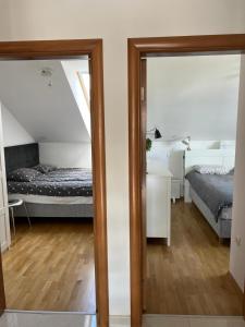 a room with a bed and a bedroom with a mirror at Ivana Rogoznica in Rogoznica