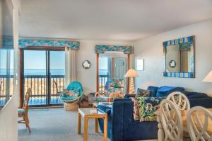 Sala de estar con sofá azul y vistas al océano en Mermaids Cove, en Nags Head