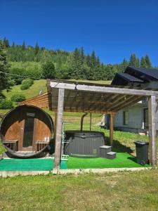a large wooden pavilion with a playground in a field at Casa Ovidiu in Pojorâta