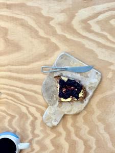 Un trozo de pastel en un plato con una taza de café. en Canaryislandshost l Canteras, en Las Palmas de Gran Canaria