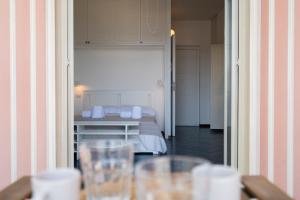 ジャルディーニ・ナクソスにあるSea View Apartment in Naxosのベッド1台、テーブル(グラス付)