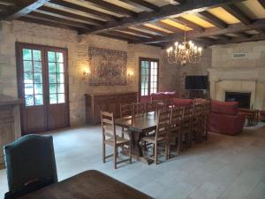 a dining room with a table and chairs and a fireplace at Le Manoir de la Feuillade in Carsac-Aillac