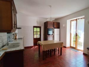a kitchen with a table and a sink in it at Le Manoir de la Feuillade in Carsac-Aillac