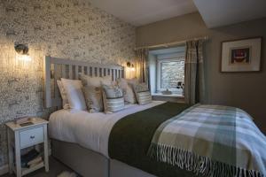 a bedroom with a bed with pillows and a window at Bridge Cottage in Hawes