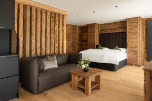 una sala de estar con una cama y un sofá en Das Denisl, en Reit im Winkl