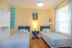 Un dormitorio con dos camas y una mesa con lámpara. en Peaceful Getaway in Windsor Hills, en Orlando