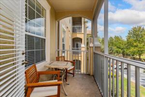 un porche con 2 sillas y una mesa en el balcón en Peaceful Getaway in Windsor Hills, en Orlando