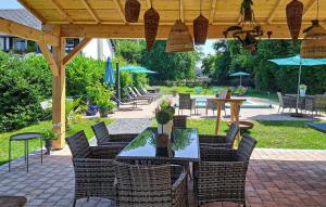 an outdoor patio with tables and chairs and umbrellas at Beautiful Home In Thierville With Wifi in Thierville +32 photos