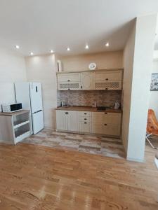a kitchen with white cabinets and a white refrigerator at Аркадия с панорамой моря in Odesa