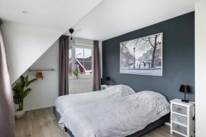 a bedroom with a bed and a blue wall at Casa Grande - cityview Amsterdam in Landsmeer