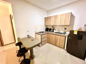 a small kitchen with a table and a refrigerator at Baum Loft Santa Rita 204 in Cali