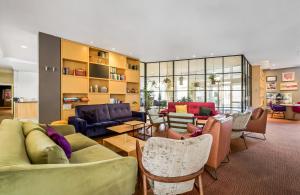 a large living room with couches and chairs at Leonardo Hotel Hannover Medical Park in Hannover