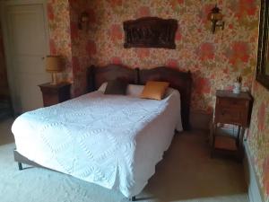 a bedroom with a bed with white sheets and floral wallpaper at Maison de charme de 8 à 13 personnes in Charlieu +7 photos