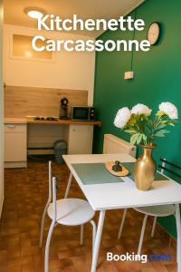 a white table and chairs with a vase of flowers at Carcassonne Studio in Carcassonne