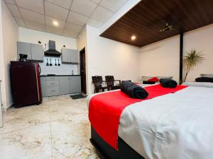 a bedroom with a large bed with a red blanket at ADH Royal Dot Inn in Mysore +79 photos