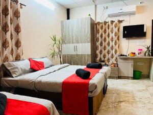 a room with two beds with a red blanket at ADH Royal Dot Inn in Mysore