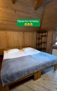 a bed in a room with a sign on the wall at Girskiy Prutets in Bukovel