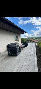 a wooden deck with two couches on top of a house at La Maison du Rond-Buisson in Maîche