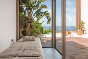 a bedroom with a large sliding glass door with a couch at Irida Mindful Living - Adults Friendly 14 Plus in Agia Pelagia