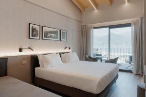a hotel room with a bed and a large window at Lago Dorato Marina Lodge - Lakefront in Colico