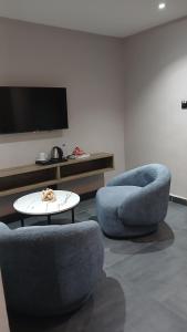2 blaue Stühle und ein Tisch im Wohnzimmer in der Unterkunft Zero Degrees Hotel in Port Harcourt + 12 Fotos