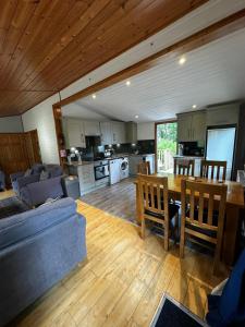 a kitchen and living room with a table and a couch at The Retreat in Berrynarbor