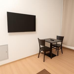 una mesa y sillas en una habitación con TV en la pared en UrbanStay 2, en Viena