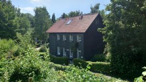 a house with a red roof in a garden at Bergisch Grün in Wuppertal