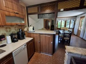 a kitchen with wooden cabinets and a dining room at Faludi vendégház in Vonyarcvashegy