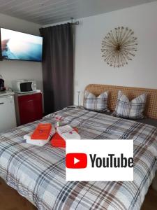 una camera da letto con un letto con un cartello di YouTube sopra di Beau studio avec terrasse et vue EXCLUSIVEMENT POUR NON FUMEURS a Belmont-sur-Lausanne