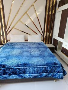 a bedroom with a bed with a blue comforter at Model Apartment in Bhurban