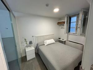 Un dormitorio pequeño con una cama y una ventana. en Pensión Rua Nova, en Santiago de Compostela