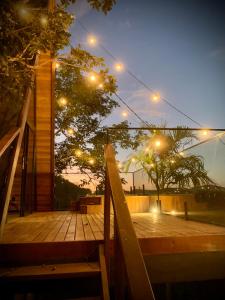 a wooden deck with a bench and lights at night at Cabanas do Cerrado Brasil in Novo Gama