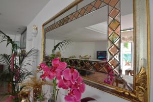a mirror with a vase of flowers in front of it at Hotel Galassi in Numana