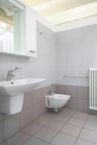 a white bathroom with a sink and a toilet at APPARTAMENTO MODERNO con parcheggio gratuito di fronte in Lecco +44 photos
