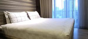 a bedroom with a large white bed with a large window at CozyNest Suites Bukit Bintang in Kuala Lumpur +20 photos