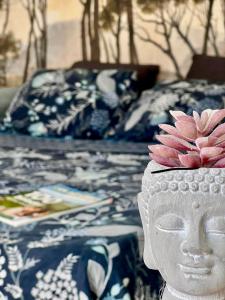 a white vase with a flower on top of a bed at Lyon Chambre pour une personne chez Dalia in Lyon