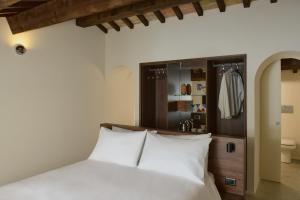 a bedroom with a white bed and a closet at Scavolo Borgo in SantʼAgata Feltria