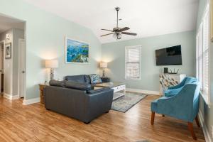 een woonkamer met een bank en een tv bij Nadines Nest in Kitty Hawk