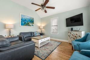 een woonkamer met een bank en een plafondventilator bij Nadines Nest in Kitty Hawk