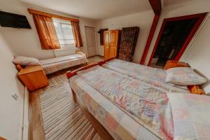 a bedroom with two beds and a tv in it at Pensiunea Patakparti in Praid +15 photos