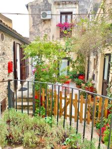 una recinzione di legno di fronte a una casa con fiori di Casa Dolce Casa a Modica Altre 5 foto