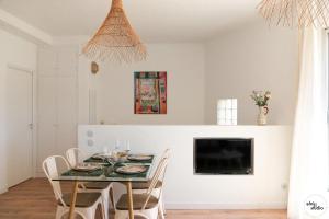 a dining room with a table with chairs and a tv at Terrasse Matisse in Collioure