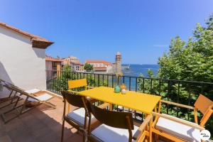 a yellow table on a balcony with a view of the ocean at Terrasse Matisse in Collioure