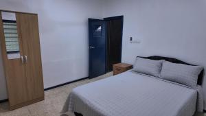 Un dormitorio con una cama y una puerta azul. en Jetsetter's Haven, en Nadi