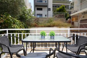a table and chairs with plants on a balcony at house blue sea in Iraklitsa